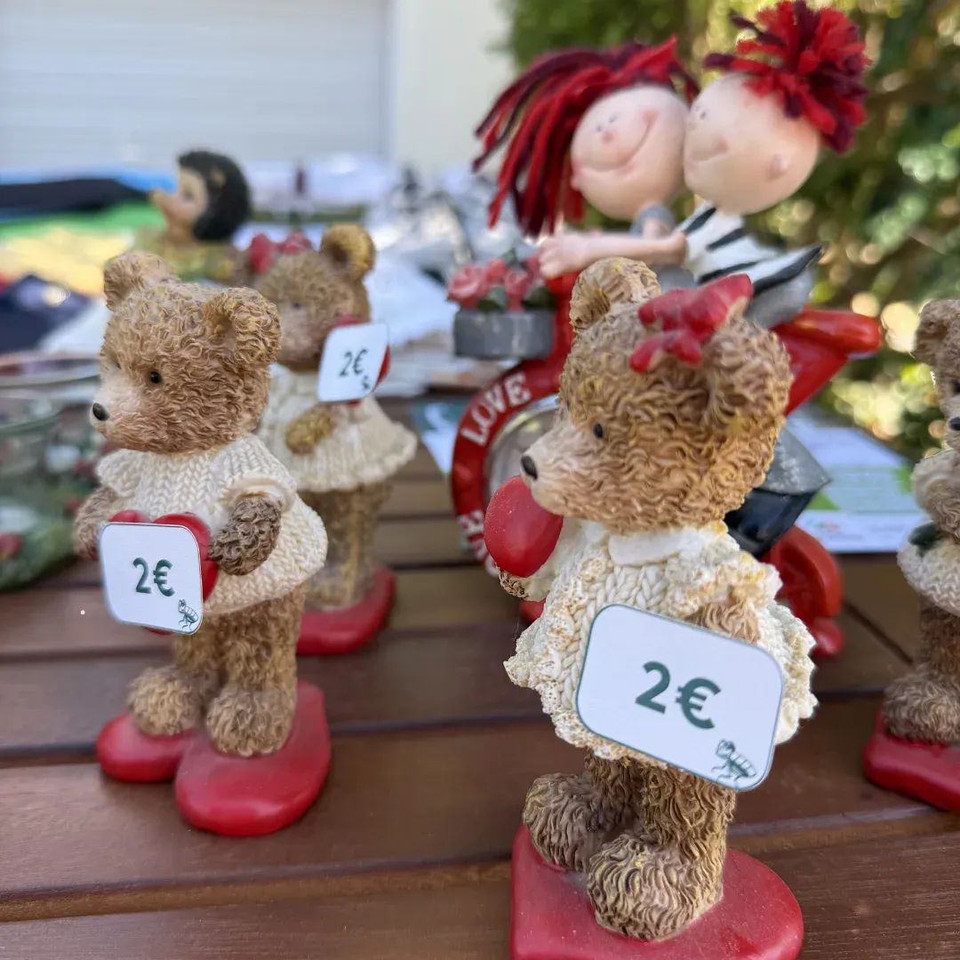 Teddybär-Figuren mit 2-Euro-Preisschildern auf einem Holztisch